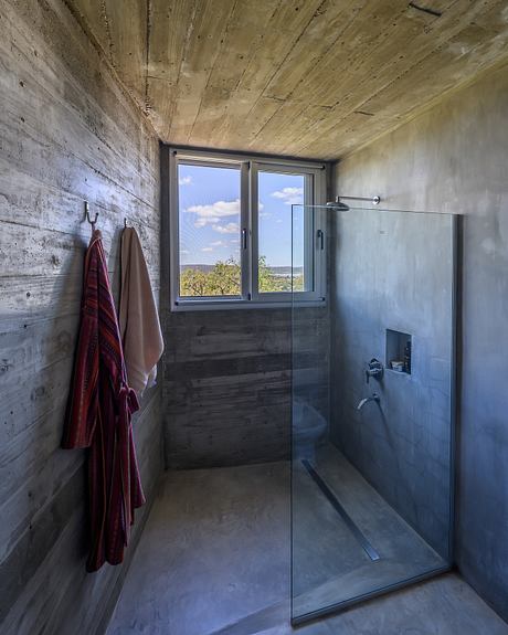 Casa Cosmos: Rammed Stone and Exposed Concrete on a Sloped Site Edge - 9