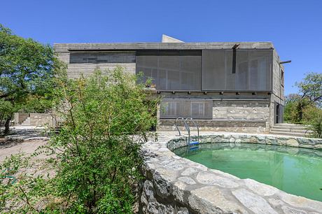 Casa Cosmos: Rammed Stone and Exposed Concrete on a Sloped Site Edge - 11