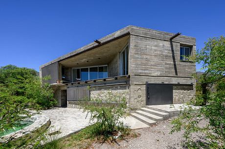 Casa Cosmos: Rammed Stone and Exposed Concrete on a Sloped Site Edge - 12